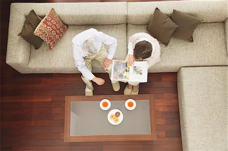 retired lady friends - Above view of senior adult couple having tea and reading a book on the sofa Stock Photo - Rights-Managed, Code: 859-06470201