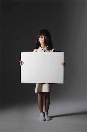 scheinwerfer - Girl in a white dress holding a white board Stockbilder - Lizenzpflichtiges, Bildnummer: 859-06537715