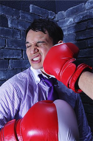 Businessman with boxing gloves getting punched Stockbilder - Lizenzpflichtiges, Bildnummer: 859-06537884