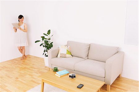 floor cushion - Woman using tablet in a living room Stock Photo - Rights-Managed, Code: 859-06537902