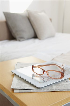 Glasses tablet and newspaper on bed Stockbilder - Lizenzpflichtiges, Bildnummer: 859-06538427