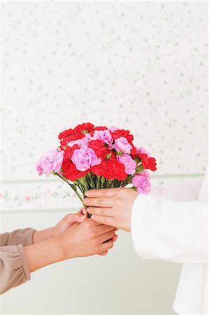 Girl Giving Flower Present To Her Mother Photographie de stock - Rights-Managed, Code: 859-06617371