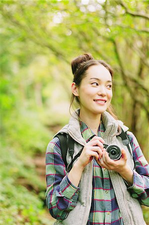 simsearch:859-06824605,k - Young girl with camera in a forest smiling away Stock Photo - Rights-Managed, Code: 859-06824594