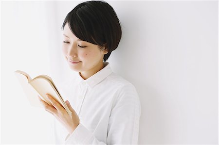 simsearch:859-06824638,k - Young woman in a white shirt reading a book Fotografie stock - Rights-Managed, Codice: 859-06824633