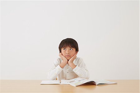 Young boy doing his homework on wooden desk Stock Photo - Rights-Managed, Code: 859-07710979