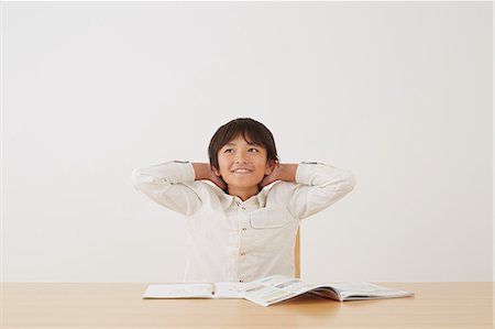 Young boy doing his homework on wooden desk Stock Photo - Rights-Managed, Code: 859-07710984