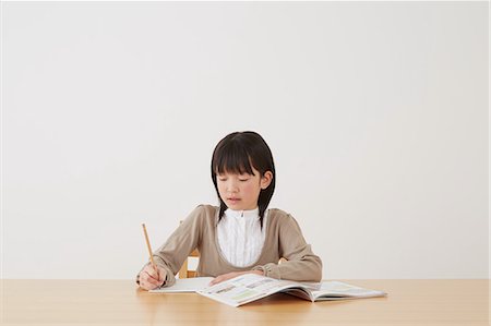 simsearch:859-07710990,k - Young girl doing her homework on wooden desk Stock Photo - Rights-Managed, Code: 859-07710989