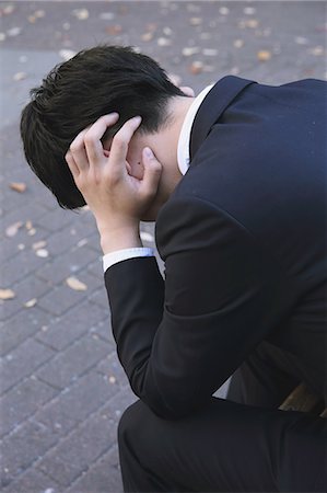 simsearch:859-06537705,k - Desperate Japanese young businessman in a suit sitting on a bench in a park Stock Photo - Rights-Managed, Code: 859-07711095