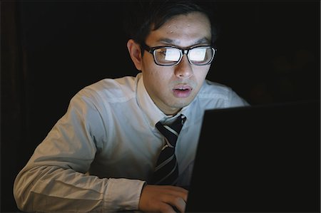 desk dark - Japanese young businessman working late at his laptop Stock Photo - Rights-Managed, Code: 859-07711114