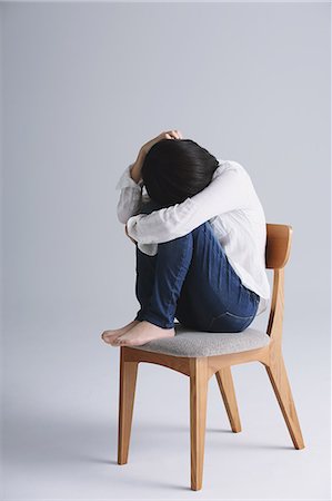 desesperado - Desperate Japanese young woman in a white shirt sitting on a chair Foto de stock - Con derechos protegidos, Código: 859-07711129