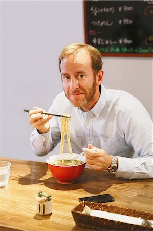 simsearch:859-06537942,k - Caucasian man with beard eating ramen noodles Stock Photo - Rights-Managed, Code: 859-08173134