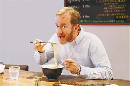 simsearch:859-07150143,k - Caucasian man with beard eating ramen noodles Foto de stock - Con derechos protegidos, Código: 859-08173130