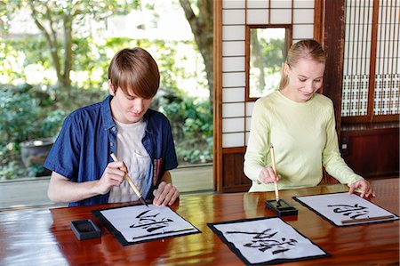 simsearch:859-08887564,k - Caucasian couple practicing calligraphy at traditional Japanese house Stockbilder - Lizenzpflichtiges, Bildnummer: 859-08887570