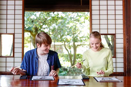 simsearch:859-03839113,k - Caucasian couple practicing calligraphy at traditional Japanese house Foto de stock - Con derechos protegidos, Código: 859-08887571