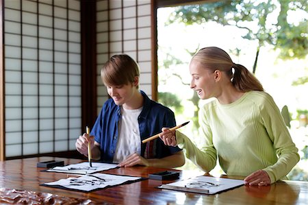 simsearch:693-03312841,k - Caucasian couple practicing calligraphy at traditional Japanese house Fotografie stock - Rights-Managed, Codice: 859-08887617