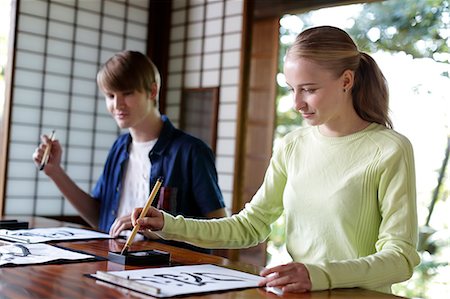 simsearch:693-03312841,k - Caucasian couple practicing calligraphy at traditional Japanese house Fotografie stock - Rights-Managed, Codice: 859-08887618