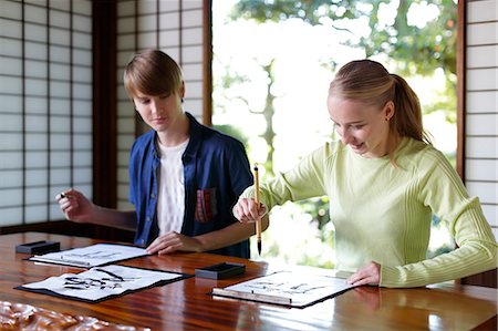 simsearch:693-03312841,k - Caucasian couple practicing calligraphy at traditional Japanese house Fotografie stock - Rights-Managed, Codice: 859-08887620