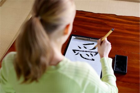 desk directly above - Caucasian woman practicing calligraphy at traditional Japanese house Stock Photo - Rights-Managed, Code: 859-08887622