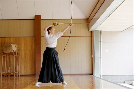 simsearch:859-09018715,k - Caucasian woman practicing traditional Kyudo Japanese archery Foto de stock - Con derechos protegidos, Código: 859-09018718