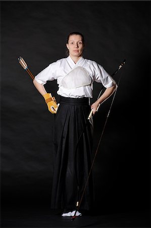 simsearch:859-09018730,k - Caucasian woman practicing traditional Kyudo Japanese archery on black background Stock Photo - Rights-Managed, Code: 859-09018733