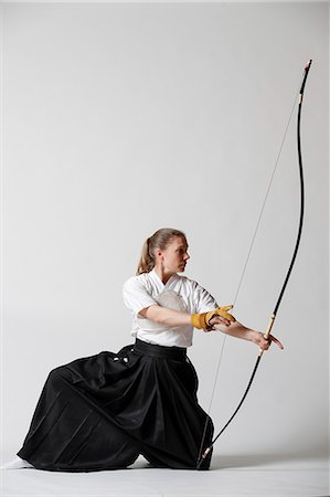 female martial arts images - Caucasian woman practicing traditional Kyudo Japanese archery on white background Stock Photo - Rights-Managed, Code: 859-09018740