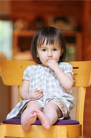 simsearch:859-09018844,k - Mixed-race young girl eating on wooden chair Fotografie stock - Rights-Managed, Codice: 859-09018823