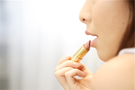 rouge - Young woman applying lipstick Stock Photo - Rights-Managed, Code: 859-03036032