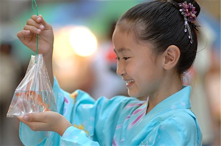 Young girl in yukata holding goldfish Stock Photo - Rights-Managed, Code: 859-03037230