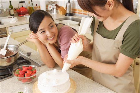 decorating cakes - Women frosting cake with icing bag Stock Photo - Rights-Managed, Code: 859-03038425