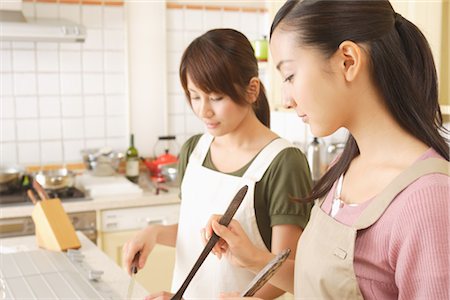 simsearch:693-06324763,k - Side view of women cooking food in kitchen Stock Photo - Rights-Managed, Code: 859-03038433