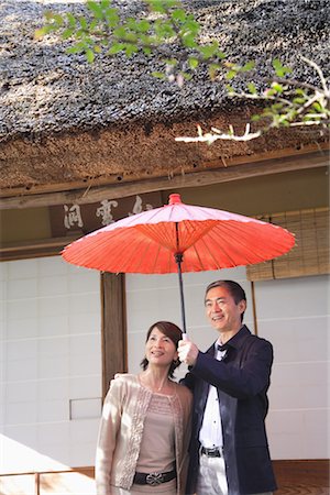 senior couple candid outdoors - Vue de face d'un parapluie de tenue de couple d'âge mûr Photographie de stock - Rights-Managed, Code: 859-03038528