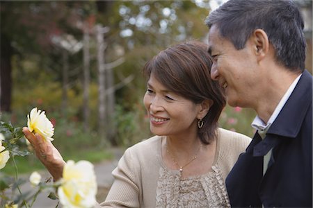 senior couple candid outdoors - Middle-aged couple looking at flower Stock Photo - Rights-Managed, Code: 859-03038543