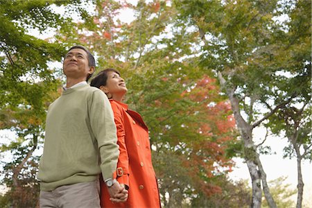 senior couple candid outdoors - Vue latérale d'un couple d'âge moyen debout dos à dos Photographie de stock - Rights-Managed, Code: 859-03038554