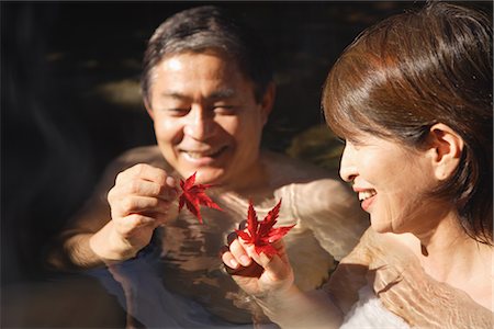 Middle-aged couple holding maple leaves in natural hot spring Foto de stock - Con derechos protegidos, Código: 859-03038565