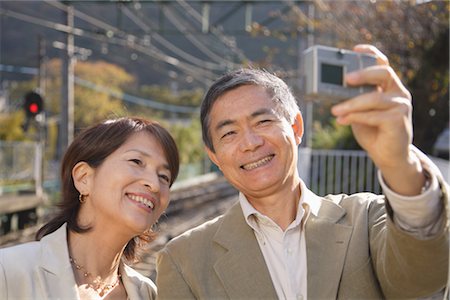 senior couple candid outdoors - Vue de face d'un couple photo prise avec l'appareil photo numérique Photographie de stock - Rights-Managed, Code: 859-03038584