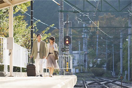 senior couple candid outdoors - Front view of couple walking on railway platform Stock Photo - Rights-Managed, Code: 859-03039265