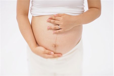 simsearch:859-03600068,k - Pregnant Woman Standing Holding her Belly Fotografie stock - Rights-Managed, Codice: 859-03600087