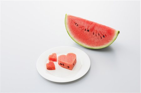 simsearch:859-03600292,k - Slices of Heart shaped Watermelon in Plate Foto de stock - Con derechos protegidos, Código: 859-03600265