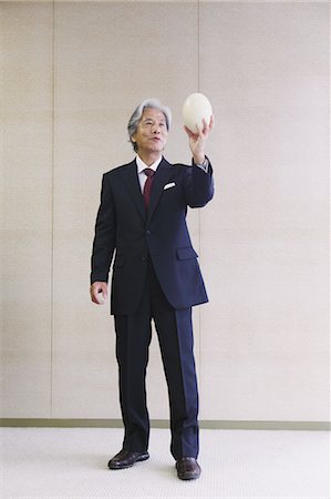 Executive Businessman Holding Egg Of Ostrich Foto de stock - Con derechos protegidos, Código: 859-03600359