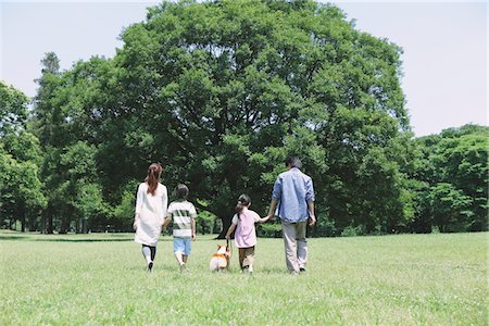family walking in park holding hands - Family In a Park With Pet Stock Photo - Rights-Managed, Code: 859-03755350