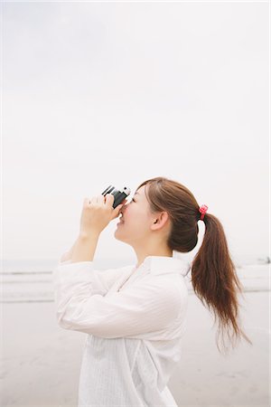 stylish people taking photos - Young Woman Taking A Picture Stock Photo - Rights-Managed, Code: 859-03779883