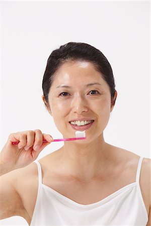 simsearch:859-03779974,k - Portrait Of Woman Holding Toothbrush Fotografie stock - Rights-Managed, Codice: 859-03779983