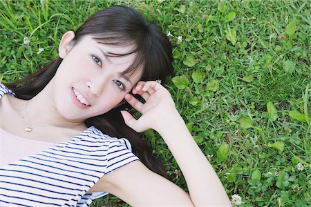 simsearch:859-03885419,k - Young Woman Lying On A Grassy Field Fotografie stock - Rights-Managed, Codice: 859-03780196