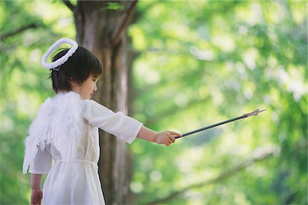 Boy Standing Holding Magic Wand Foto de stock - Direito Controlado, Número: 859-03781909