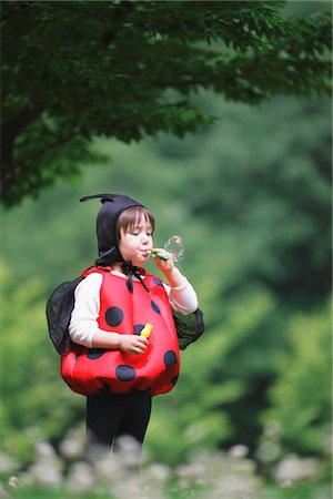 Boy as Ladybird Blowing Bubbles Fotografie stock - Rights-Managed, Codice: 859-03781970