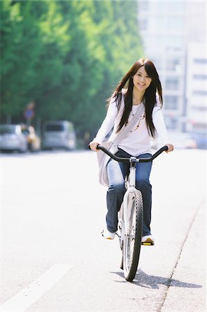 Japanese Young Woman  Riding  Bicycle on Road Foto de stock - Con derechos protegidos, Código: 859-03782144