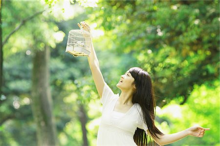Young Woman Holding Birdcage in Forest Stock Photo - Rights-Managed, Code: 859-03782212