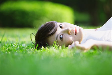 Young Woman Lying on Grass In Park Stock Photo - Rights-Managed, Code: 859-03782227