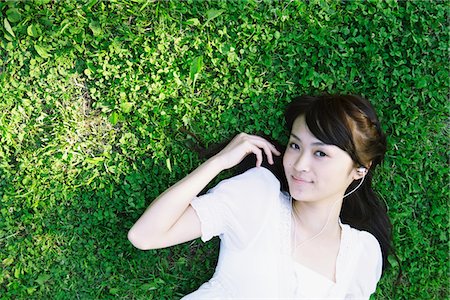 earplug - Young Woman Lying on Grass and Listening Music Stock Photo - Rights-Managed, Code: 859-03782234