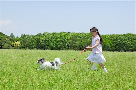 Fille en cours d'exécution dans le parc avec son chien Pet Photographie de stock - Rights-Managed, Code: 859-03782341